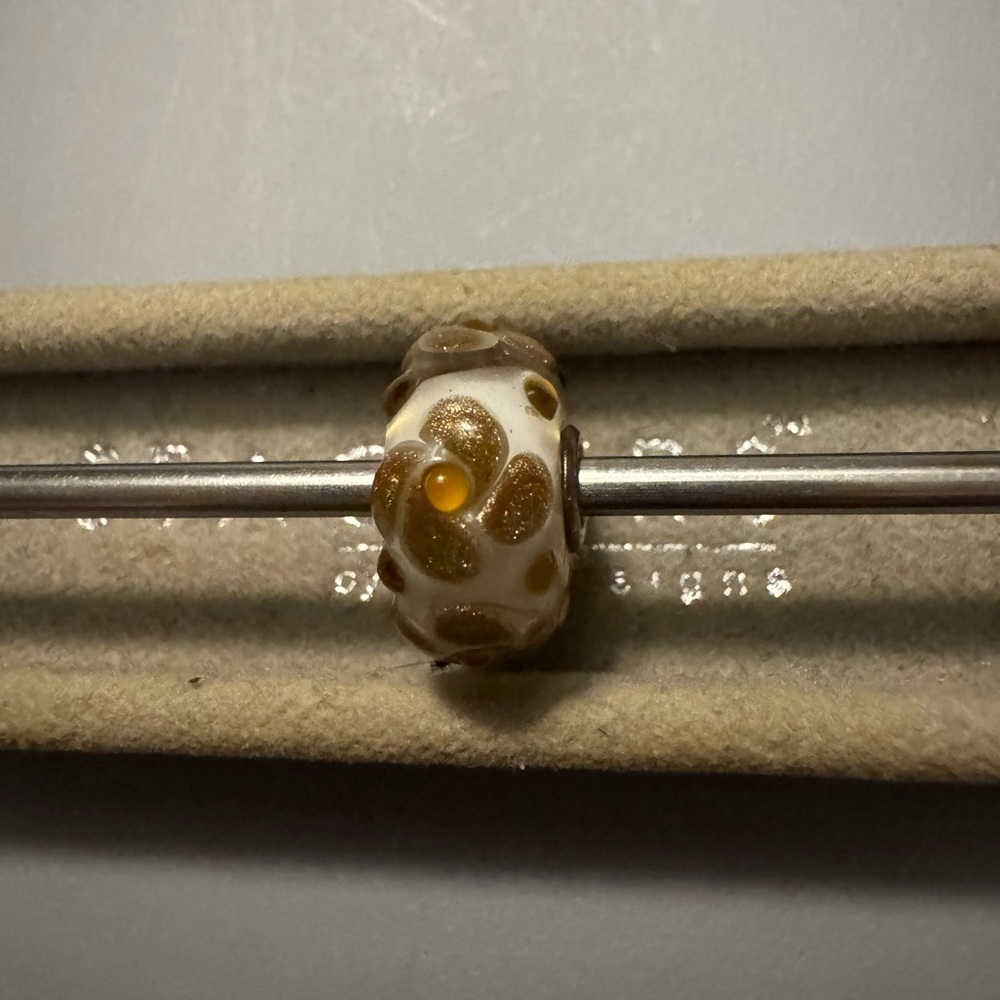 Trollbeads white base gold flowers with glitter and a orange dot in middle